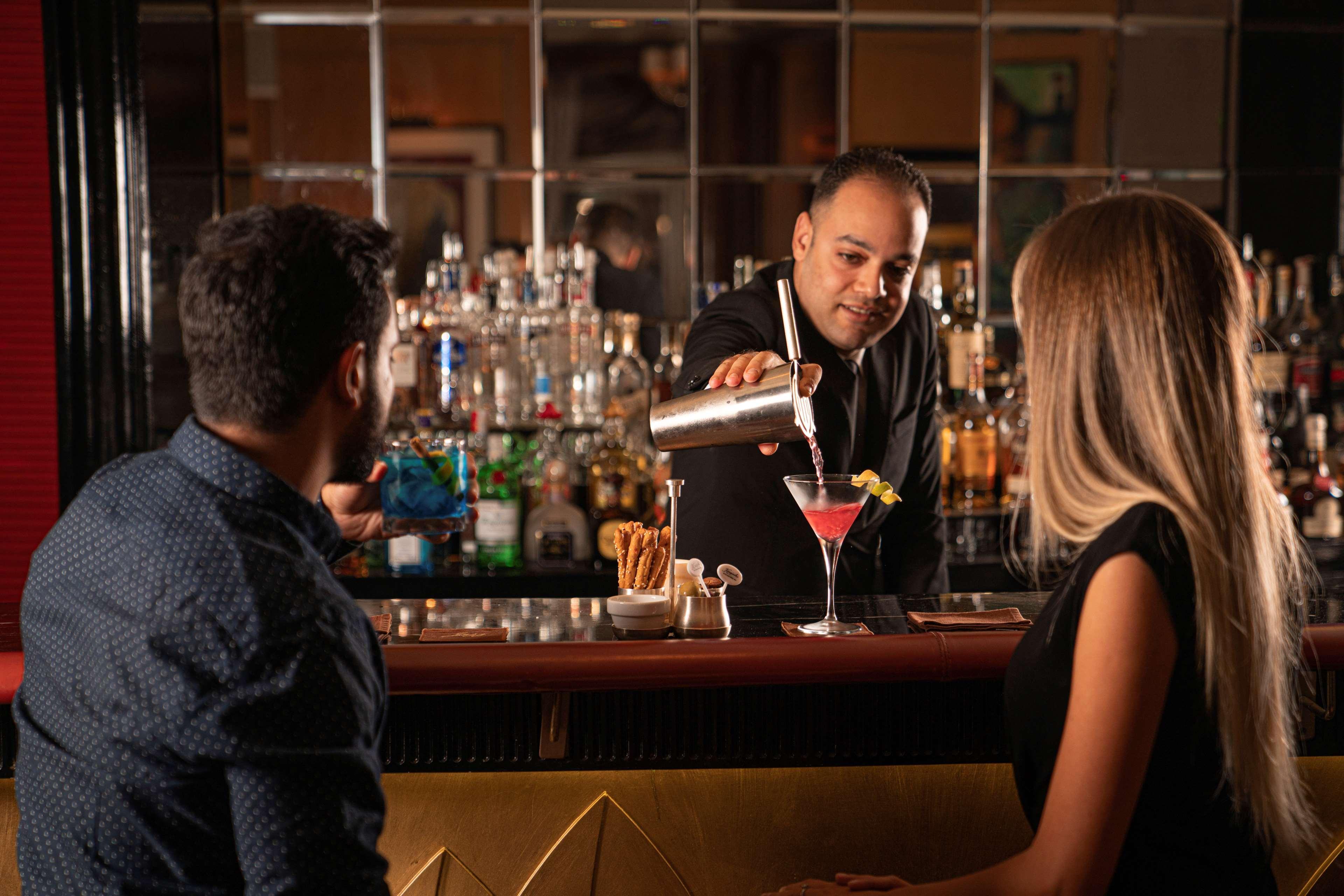 Kempinski Nile Hotel, Kairo Bagian luar foto A bartender at work